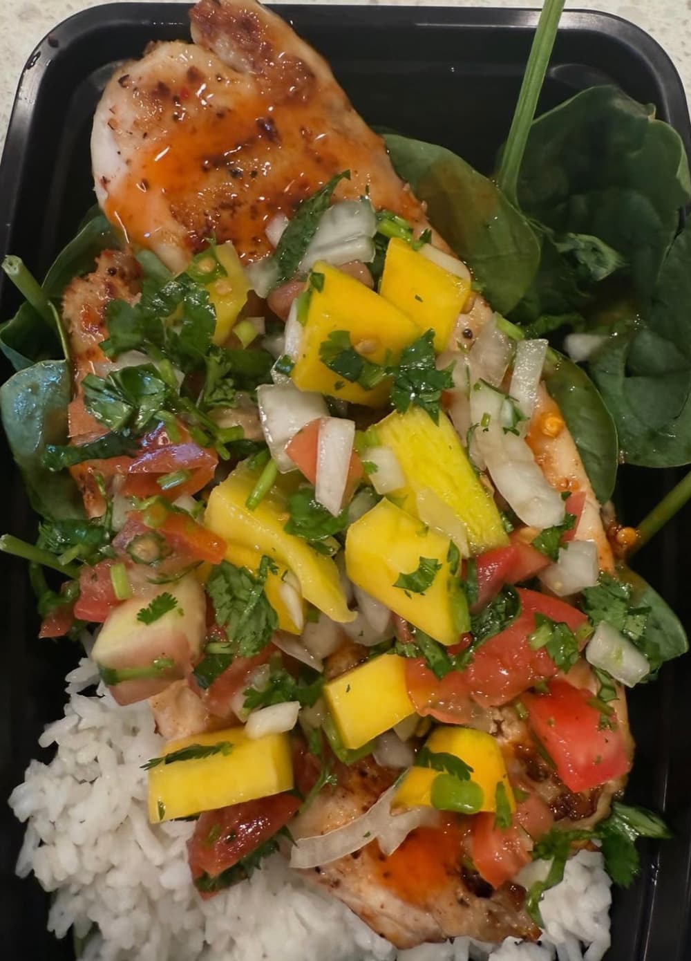 White fish topped with mango salsa over rice